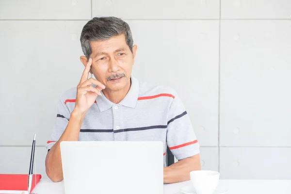 Dizüstü bilgisayar kullanan kıdemli Asyalı.