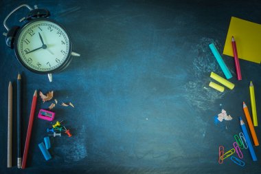 Düz Lay, Chalkboard üzerinde Okul Malzemeleri Sınır Banner Top View, retro Siyah Saat vintage, renk, Tebeşir, Kalem, Keskinci, Kağıt-Clip, Post-it, Copy Space ile Kırtasiye. Konsept Okula Dönüş.