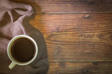 Eski mutfak ahşap masada siyah kahve ve peçete fincan. Kopyalama alanı ile üstte görünüm.