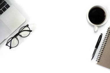 Düz yerde, dizüstü bilgisayarı, defteri, kalemi, siyah kahve fincanı ve gözlüğü olan beyaz ofis masası. Kopyalama alanı olan üst görünüm.