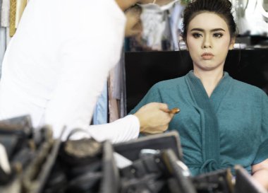 Güzel, Asyalı bir gelin soyunma odasında makyaj sanatçısının düğün makyajını yapıyor. Gelin portresi yumuşak odak noktası. Aşk kavramı, evlilik evliliği, fotokopi alanı.