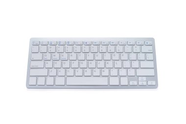 Modern bilgisayar klavyesinin üst görünümü kırpma yolu ile beyaz arkaplanda izole edildi. Alüminyum ve plastikten yapılmış. İş ve internet iletişimi için kullanılan elektronik bir cihaz..