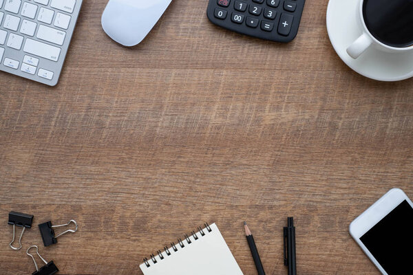 Workspace in office with wood table. Top view from above of keyboard with notebook and coffee. Desk for modern creative work of designer. Flat lay with blank copy space. Business and finance concept.