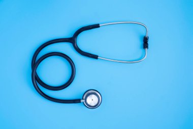 Siyah steteskop yakın plan doktor kontrol için mavi arka plan. Stetoskop ekipmanları, ses tanısı koymak için kullanılır. Fotokopi alanına sahip sağlık ve kardiyoloji kavramı.