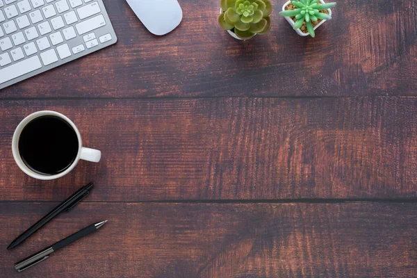 Workspace in office with wood table. Top view from above of keyboard with notebook and coffee. Desk for modern creative work of designer. Flat lay with blank copy space. Business and finance concept.