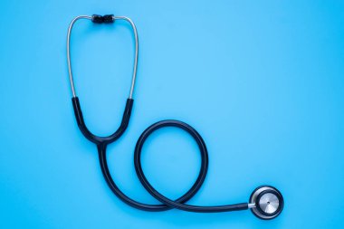 Siyah steteskop yakın plan doktor kontrol için mavi arka plan. Stetoskop ekipmanları, ses tanısı koymak için kullanılır. Fotokopi alanına sahip sağlık ve kardiyoloji kavramı.