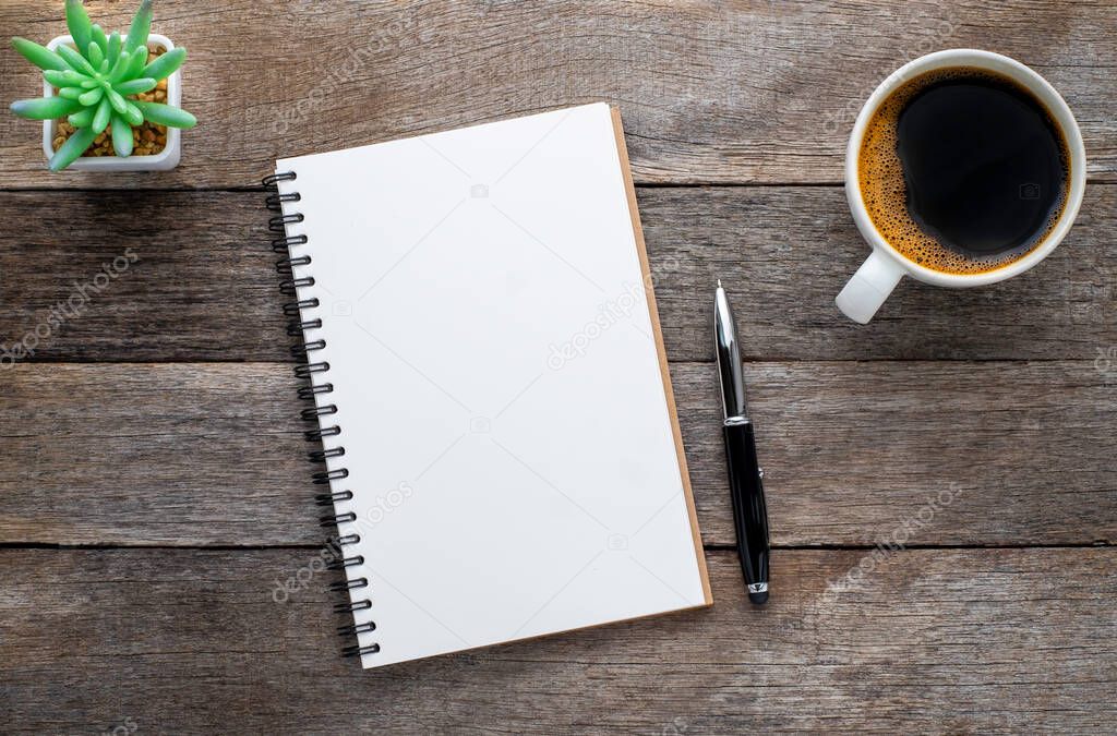 Top view from above of Blank open notebook and coffee on wood table background. Workplace for the creative work of designer at home. Flat lay, Business-finance or education concept with copy space.