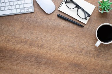 Klavyeli ahşap masa, defter, kahve fincanı ve diğer ofis malzemeleri. İş ve finans kavramı. Boş kopya alanı ile düz yatıyordu.