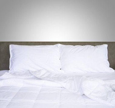 Yatak odasındaki rahat yatakta yorgan ve çarşaflı temiz, yumuşak yastıkların önü..