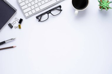 Klavyeli beyaz ofis masası, defter ve kahve fincanı diğer ofis malzemeleriyle dolu. İş ve finans kavramı. Boş kopya alanı ve üst görünümü ile düz uzandı.