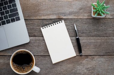 Yukarıdan bakıldığında boş bir defter, arka planda kahve fincanı olan bir klavye. Evde işyeri yaratıcılığı. Fotokopi alanı olan düz alan, işletme finansmanı veya eğitim kavramı.