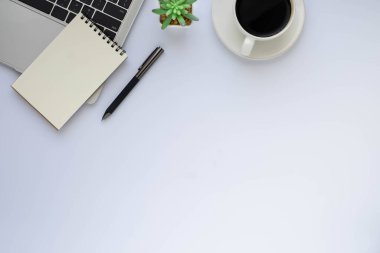 Bilgisayarlı beyaz ofis masası, defter ve kahve fincanı diğer ofis malzemeleriyle dolu. İş ve finans kavramı. Çalışma yeri, boş kopya alanı olan düz uzanma, Üst görünüm