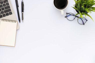 Klavyeli beyaz ofis masası dizüstü bilgisayar, defter ve ekipman ofis malzemeleriyle dolu kahve fincanı. İş ve finans kavramı. Çalışma yeri, boş kopya alanı olan düz uzanma, Üst görünüm.