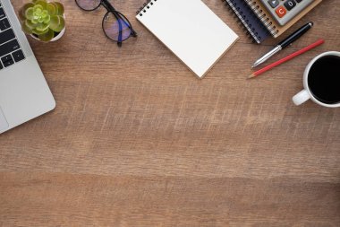 Klavyeli ahşap ofis masası dizüstü bilgisayar, defter ve ekipman ofis malzemeleriyle dolu kahve fincanı. İş ve finans kavramı. Çalışma yeri, boş kopya alanı olan düz uzanma, Üst görünüm.