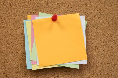 Renkli hatırlatıcı yapışkan notlar mantar panoya raptiye basıyor. boş boş alan.