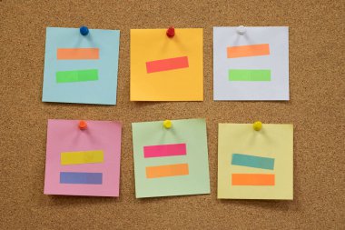 Renkli hatırlatıcı yapışkan notlar mantar panoya raptiye basıyor. boş boş alan.