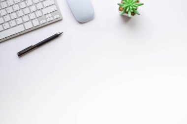 Beyaz ofis masasının üstünde klavye, defter ve fare ile diğer ofis malzemeleri. İş ve finans kavramı. Çalışma yeri, boş kopya alanı olan düz uzanma.