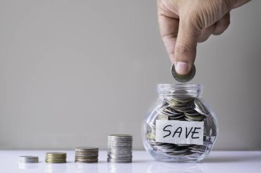 İş yatırımı ve finans muhasebe kavramı. Para dolu cam bir şişeye bozuk para koymak büyümeyi hızlandırır. Yeni bir ev almak için para biriktiriyorum..