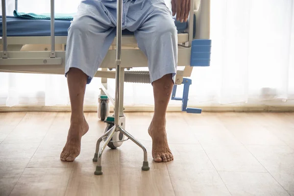 Hasta ya da yaşlı Asyalı yaşlı adam hastane veya sağlık tedavi veya tedavi için doktor ve hemşire bekleyen sopa ile hastanın yatağında yalnız oturan yürümek couldn 't