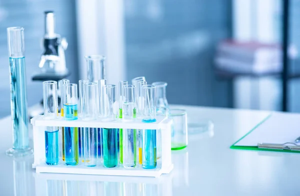 Förbereda laboratorieutrustning såsom glas, rör med blå vätska på det vita bordet. Kemi experimentet i vetenskaplig forskning — Stockfoto