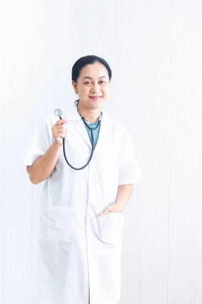 Portret pewny siebie i uśmiechnięta kobieta lekarz z białym mundurze i stetoskop (urządzenie medyczne) na białym Filmografia w szpitalu lub klinice, Asian kobieta Doktor w medycynie sukni, działalności zdrowotnej — Zdjęcie stockowe