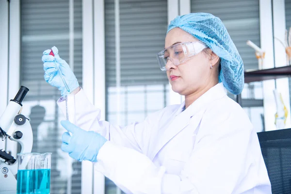 Asiatisk kvinna forskare, forskare, tekniker eller student forskat eller experimentera med Mikroskop som är vetenskaplig utrustning i medicinsk, kemi eller biologi laboratorium — Stockfoto