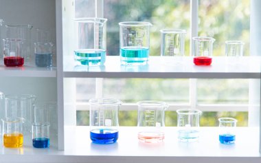 Beyaz masada mavi ve sıvı ile cam, tüp gibi laboratuar ekipmanları hazırlamak. Bilimsel araştırmalarda Kimya deneyi