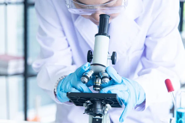 亚洲女科学家、研究员、技术员或学生使用显微镜进行研究或实验,显微镜是医学、化学或生物实验室的科学设备 — 图库照片