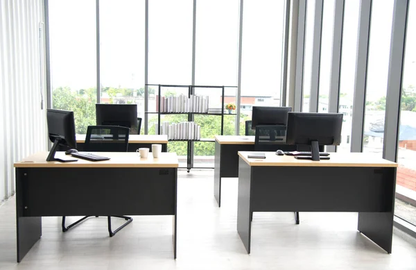 Masa, bilgisayar, monitör, insanlar olmadan oda etrafında büyük cam pencere ile Modern ofis iç tasarım