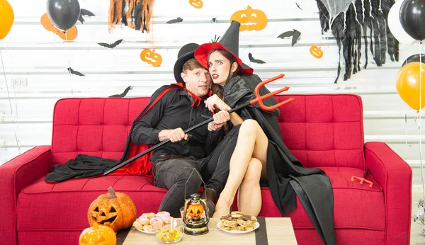 Feliz concepto de fiesta de Halloween. Joven hombre y mujer vistiendo la fantasía como vampiros, brujas o fantasmas celebran el festival de Halloween en la habitación decorada con globo, murciélago y calabaza . — Foto de Stock