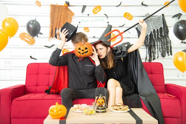 Happy Halloween party concept. Young man and woman wearing the fantacy as vampires, witch or ghost celebrate the halloween festival in the room decorated with balloon, bat and pumpkin. — Stock Photo, Image