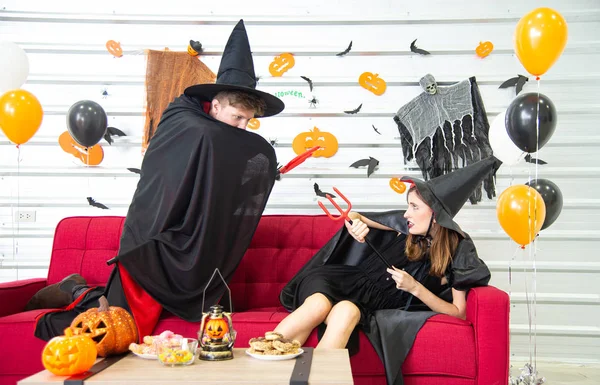 Feliz concepto de fiesta de Halloween. Joven hombre y mujer vistiendo la fantasía como vampiros, brujas o fantasmas celebran el festival de Halloween en la habitación decorada con globo, murciélago y calabaza . — Foto de Stock