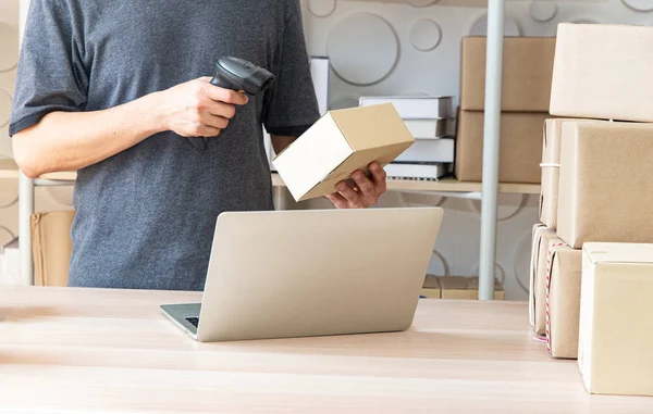 Asyalı genç akıllı işadamı veya Sme online girişimci sahibi, teslimat iş hisse senetleri veya parseller üzerinde ürün kontrol. Ev ofisinde çalışan genç küçük işletme sahibi.