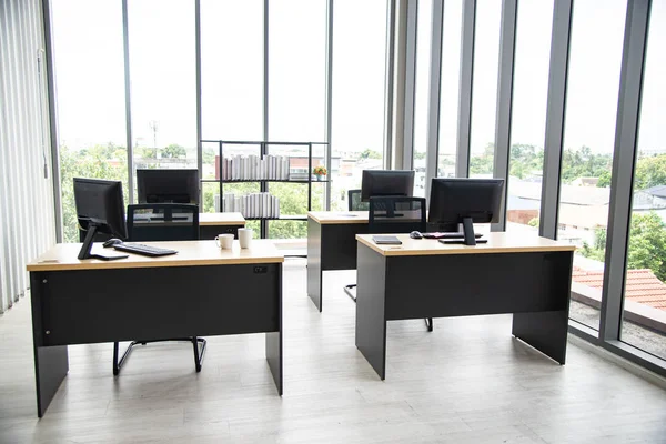 Moderne Büroeinrichtung mit Tisch, Computer, Monitor, großes Glasfenster im Raum ohne Menschen — Stockfoto