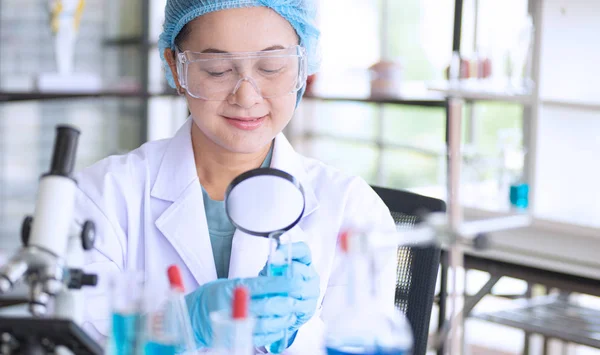 Asiatisk kvinna forskare, forskare, tekniker eller student forskat eller experimentera med Mikroskop som är vetenskaplig utrustning i medicinsk, kemi eller biologi laboratorium — Stockfoto