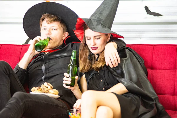 Feliz concepto de fiesta de Halloween. Joven hombre y mujer vistiendo la fantasía como vampiros, brujas o fantasmas celebran el festival de Halloween en la habitación decorada con globo, murciélago y calabaza . — Foto de Stock