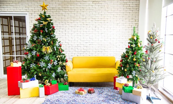Noel ve yeni yıl tatili konsepti. Noel ağacı süslemeleri, kurdeleler, kar taneleri, süsler ve beyaz tuğla duvarın üzerindeki hediye kutuları. Gece partisi için hazırlan.