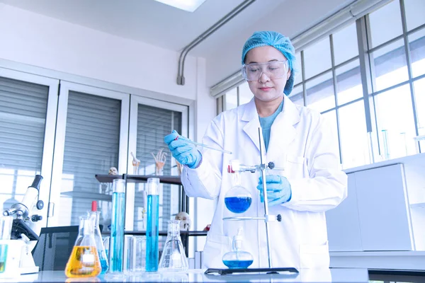 Asiatisk kvinnlig forskare, forskare, tekniker eller student som bedriver forskning eller experiment med hjälp av vetenskaplig utrustning i medicinska, kemiska eller biologiska laboratorium — Stockfoto