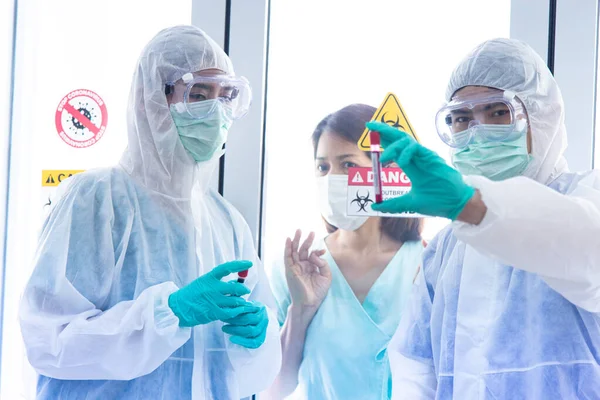 COVID-19, Corona Virüs salgını karantina ve salgın hastalık sağlıklı fikirler yaydı. Asyalı doktorlar karantina odasının önünde CORONA veya COVID-19 aşılarını gösteren PPE kişisel koruma eldiveni ve yüz maskesi takıyorlar..