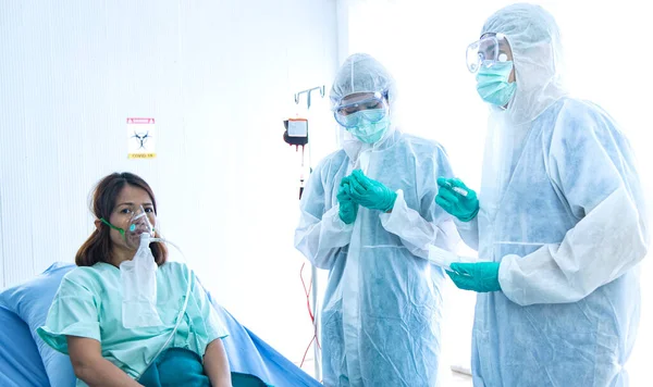 COVID-19, Corona Virüsü salgını karantina salgını yayılması ve sosyal uzaklık kavramı. Asyalı doktorlar PPE izleme cihazı takıyor ve CORONA veya COVID-19 hasta enfeksiyonu tedavisine başvuruyor