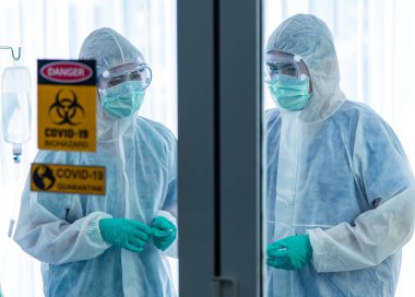 COVID-19, Corona Virüsü salgını karantina salgını yayılması ve sosyal uzaklık kavramı. Asyalı doktorlar PPE izleme cihazı takıyor ve CORONA veya COVID-19 hasta enfeksiyonu tedavisine başvuruyor
