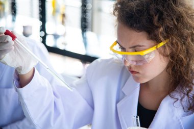 Güzel genç bilim adamları ya da araştırmacılar virüsü ya da bakteri hastalığını önlemek için kişisel koruyucu ekipman kullanıyorlar. Araştırmacılar COVID-19 aşısını laboratuvarda buldular..