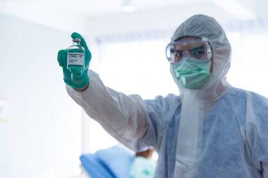 COVID-19, Corona Virüs aşısı araştırma ve geliştirme konsepti. Bulanık Asyalı doktor COVID-19 aşısı gösteriyor.