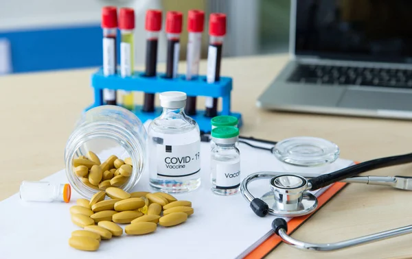 COVID-19 veya Coronavirus tedavisi ve önleyici kavram. Virüs enfeksiyonu belirtileri için ilaç hapları. Coronavirus aşısı ve pozitif hasta enfeksiyonu laboratuarda kan testi..