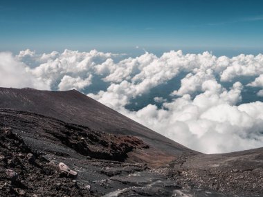 Bulutların üstünde bir yanardağ üzerinde dağlarda