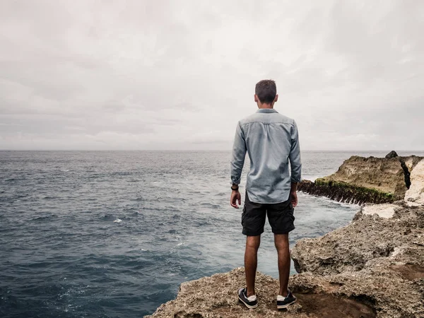 Ein einsamer Mann mit Blick auf den Ozean. Stockbild
