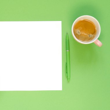 Yeşil kalem ve kahve fincanı yeşil zemin üzerine boş kağıt. Alan arka plan, üstten görünüm düz lay ek yükü kopyalama