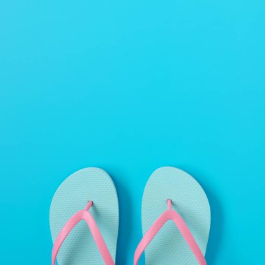 Mavi arka plan üzerinde parmak arası terlik. Yaz konsepti. Kopyalama alanı kompozisyon