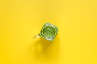 Sarı zemin üzerine taze hazırlanmış yeşil smoothie. Temiz yemek. Genel gider Gıda çekim