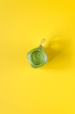 Sarı zemin üzerine taze hazırlanmış yeşil smoothie. Temiz yemek. Genel gider Gıda çekim